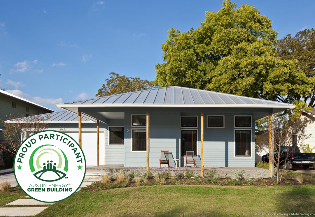 Exterior of blue home with metal roof and five-star Austin Energy Green Building badge