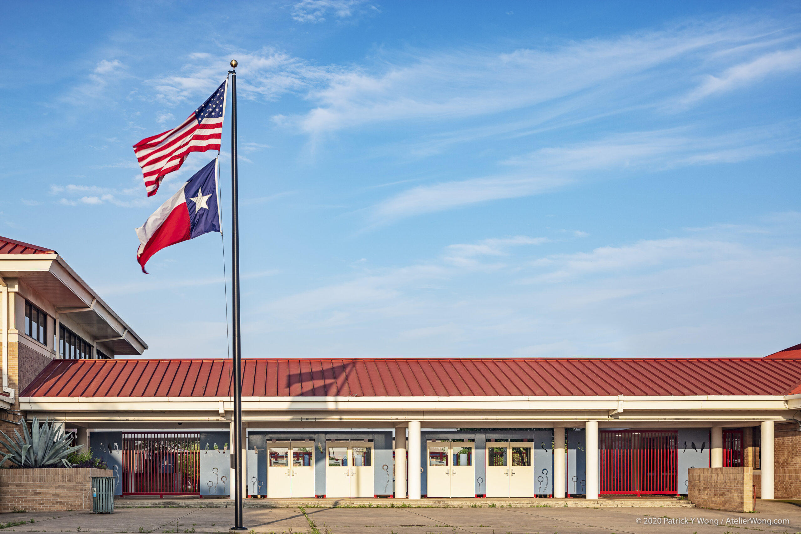 School entrance with Texas flag, updated facade, and red roof detail