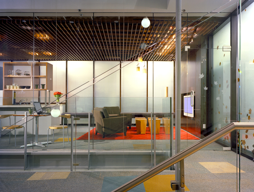 Multi-level lounge area with globe pendant lighting, glass railings, and orange carpet accents