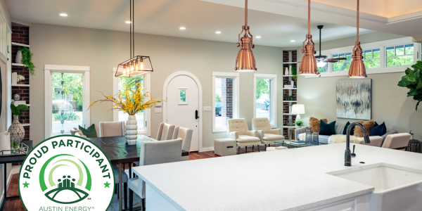 Open kitchen and dining area with copper pendant lights and Austin Energy Green Building badge