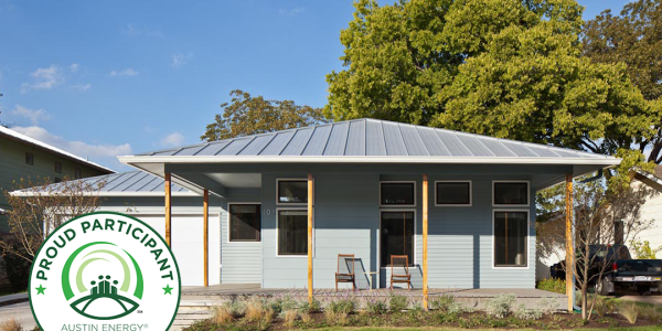 Exterior of blue home with metal roof and five-star Austin Energy Green Building badge