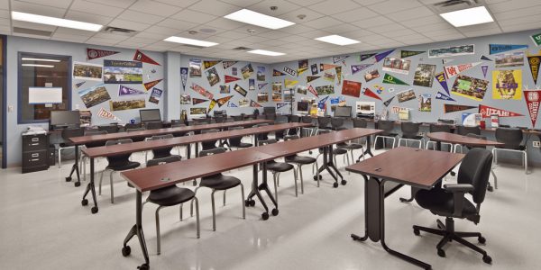 Bright classroom featuring colorful world map wall mural and student workstations
