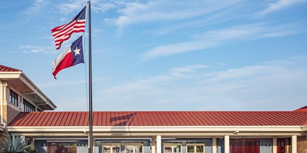 School entrance with Texas flag, updated facade, and red roof detail