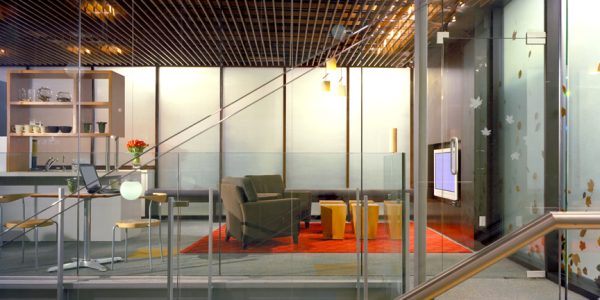 Multi-level lounge area with globe pendant lighting, glass railings, and orange carpet accents